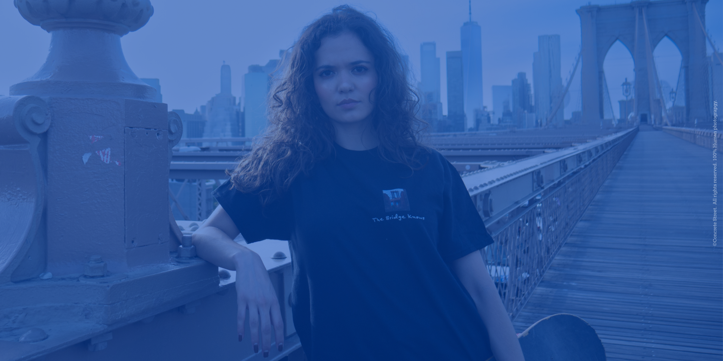 Woman standing on a bridge with a city skyline in the background